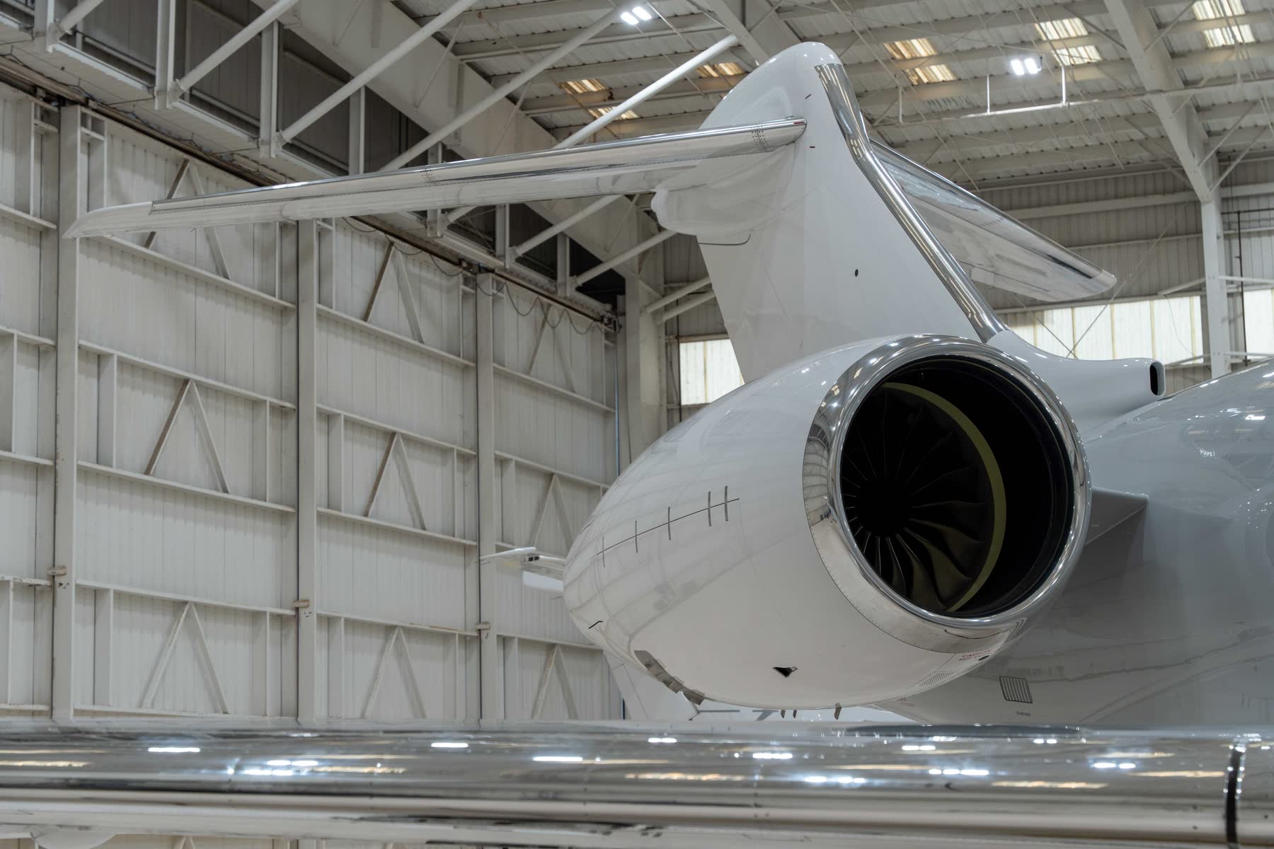 Rear-mounted engine and tail of a business jet in a hangar